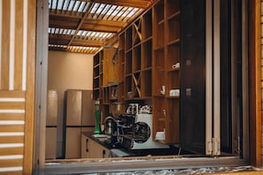 A kitchen with wooden cabinets, a stainless steel refrigerator, and a coffee machine. - VELVET SUITES - KIMIRONKO (Kigali)