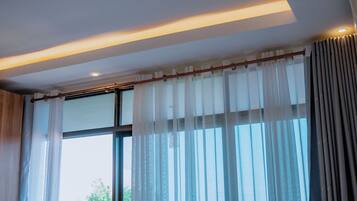 A room with large windows, a wooden ceiling, and a curtain rod.