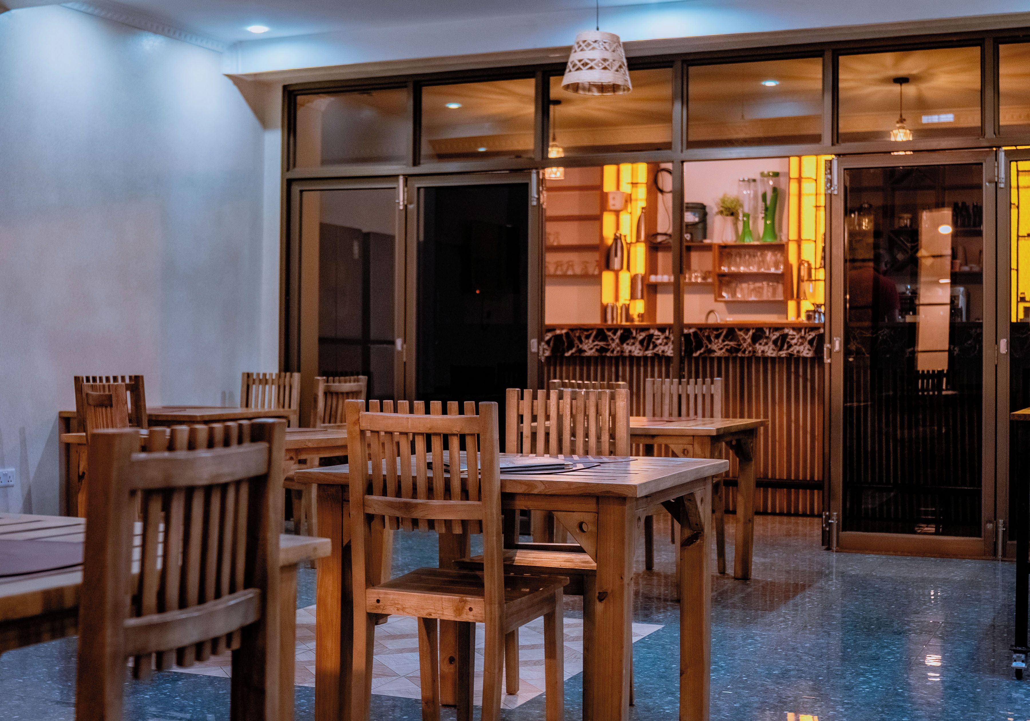 Interior de restaurante con mobiliario de madera y una zona de bar.
