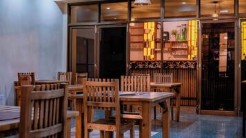 Interior de restaurante con mobiliario de madera y una zona de bar.