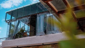 A modern building with large glass windows and a balcony.