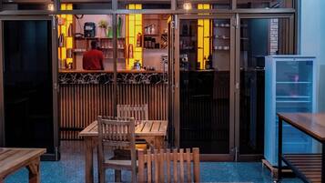 A restaurant interior with a bar area, seating, and a refrigerator.