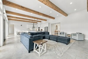 A spacious living area with a sectional sofa, a coffee table, and a fireplace. - Lone Start Lookout@FrioRiverVactionRentals (Concan)
