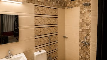 A bathroom with a toilet, sink, and shower.
