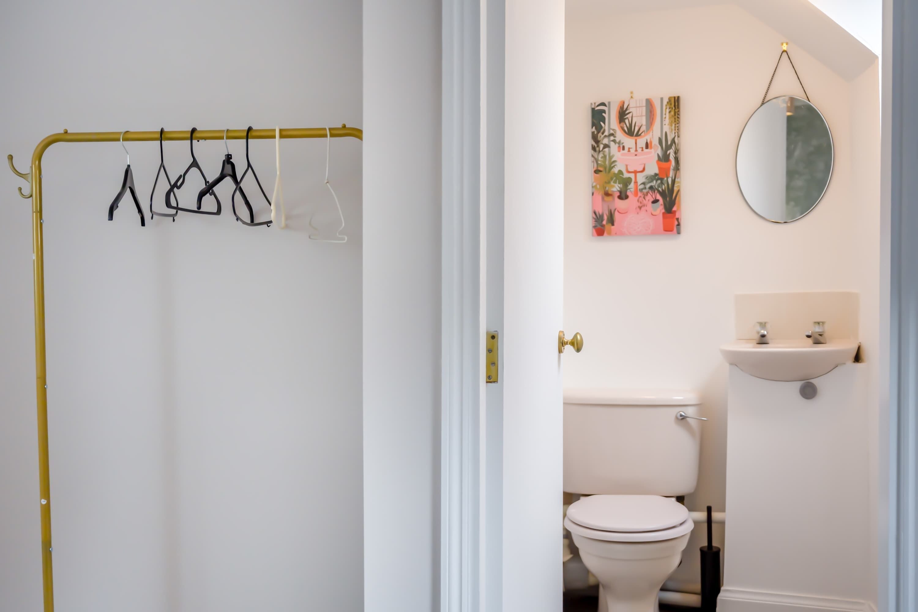 A bathroom with a toilet, a sink, and a mirror.