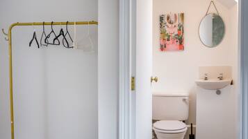 A bathroom with a toilet, a sink, and a mirror.
