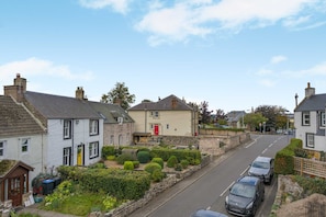 A residential street with houses, parked cars, and a clear sky. - Host Stay - Lime Cottage (Kelso)
