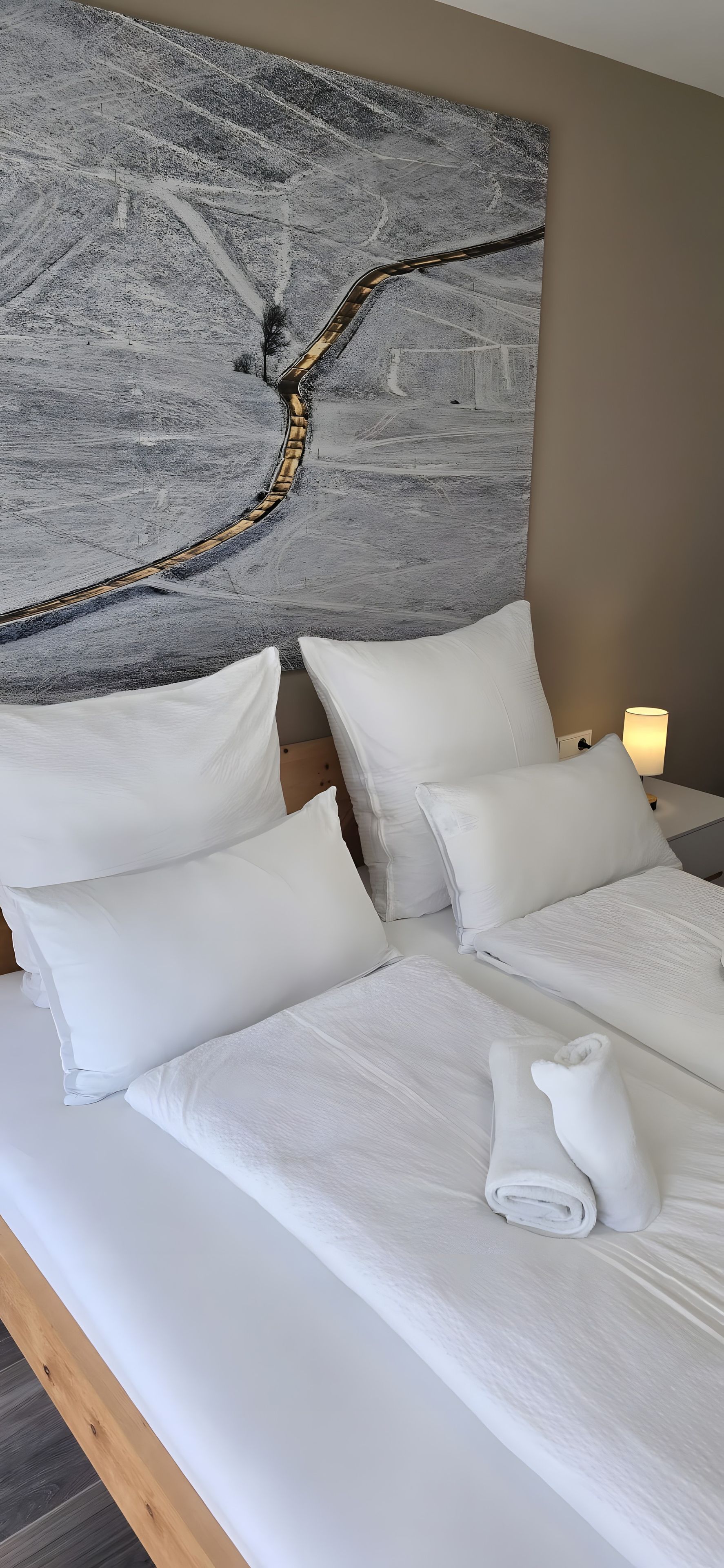 Ein Hotelzimmer mit einem großen Bett, weißer Bettwäsche und einem Bild an der Wand.