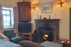 Ein Wohnzimmer mit Fernseher, Kamin und Sitzecke.
