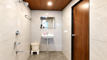 A bathroom with a wooden ceiling, a sink, a mirror, a shower, and a toilet.