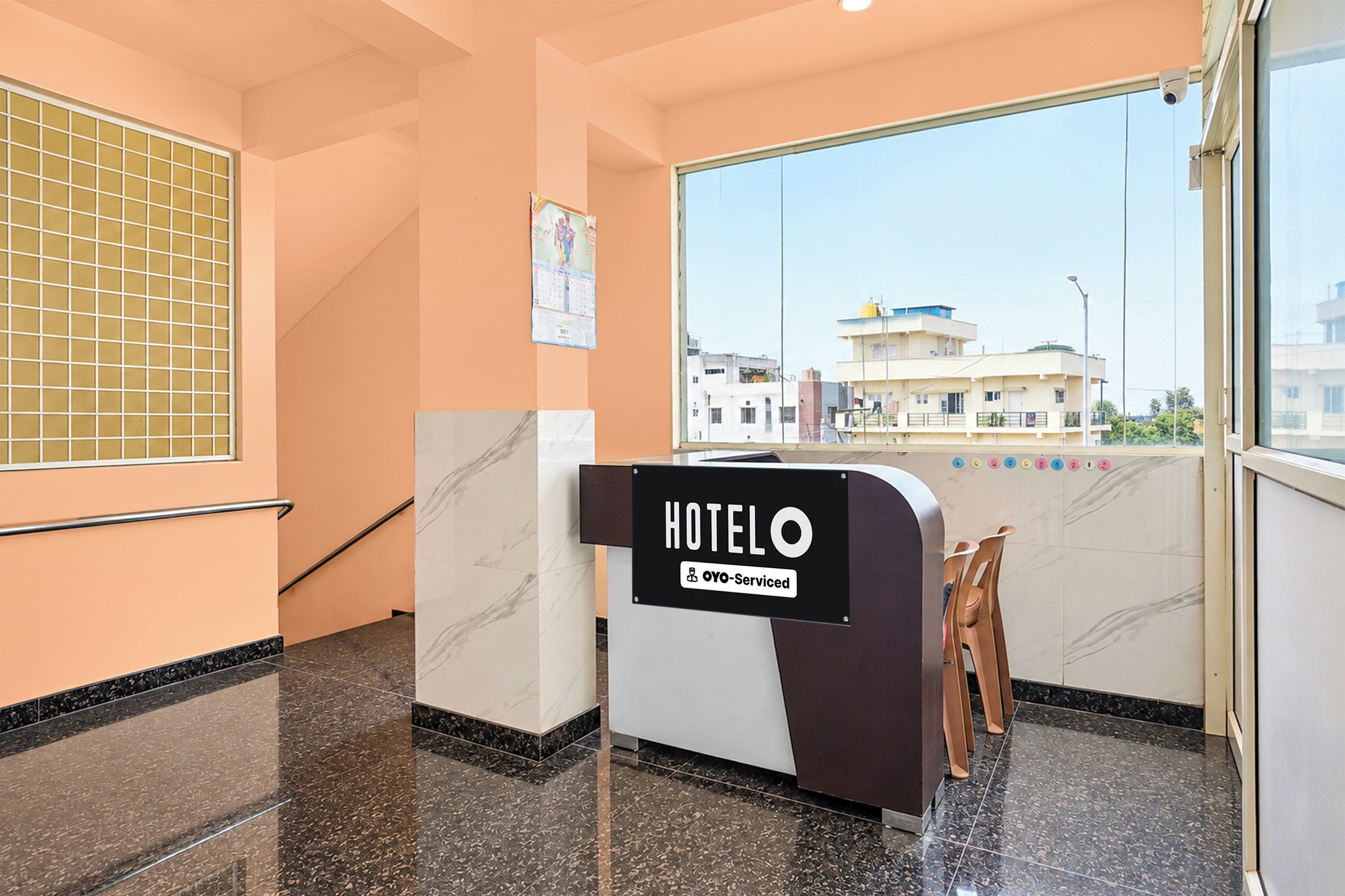 A hotel reception area with a sign indicating it is serviced by OYO.