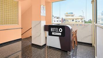 A hotel reception area with a sign indicating it is serviced by OYO.
