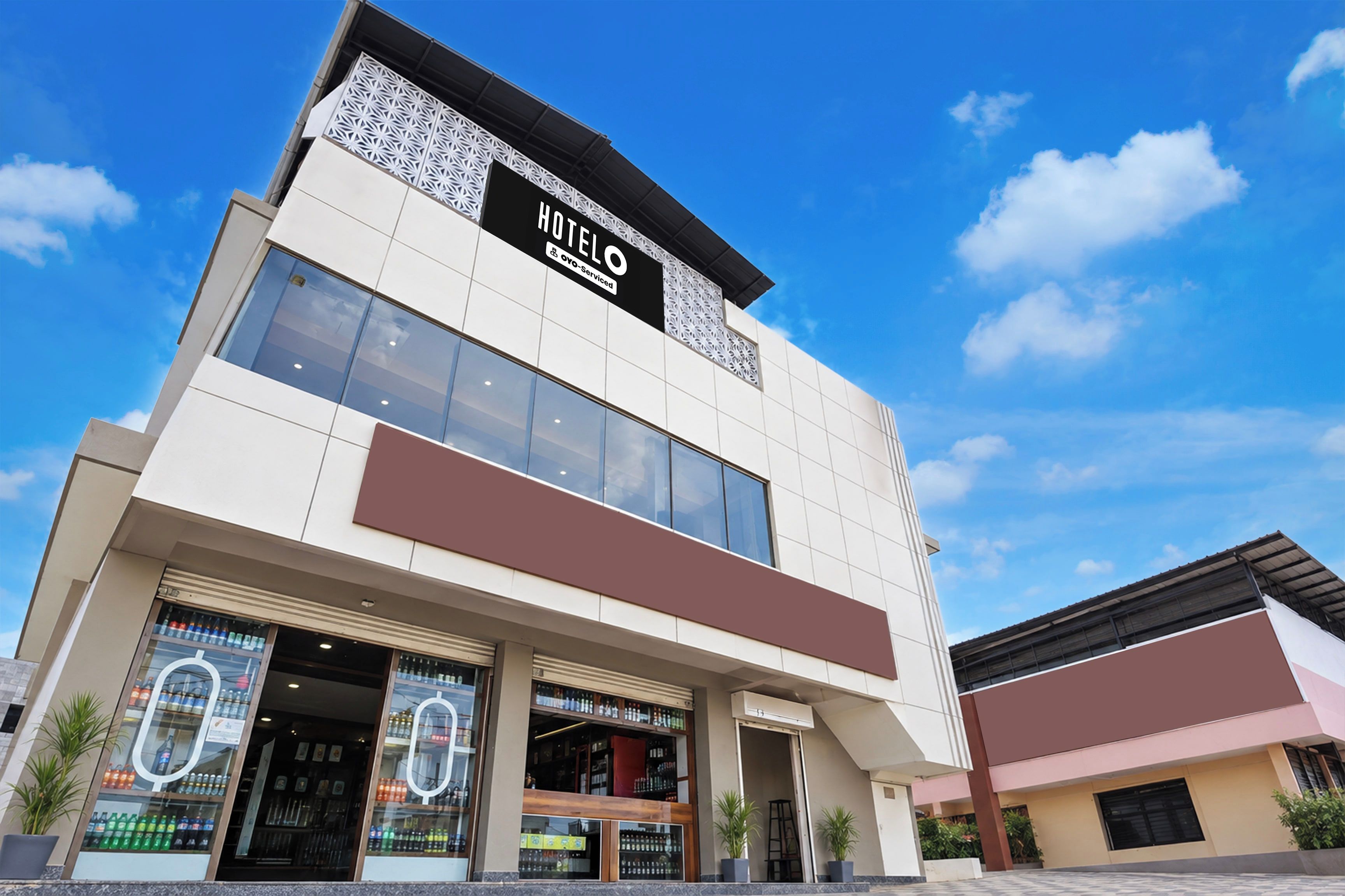 A hotel with a modern facade, large windows, and a prominent sign.
