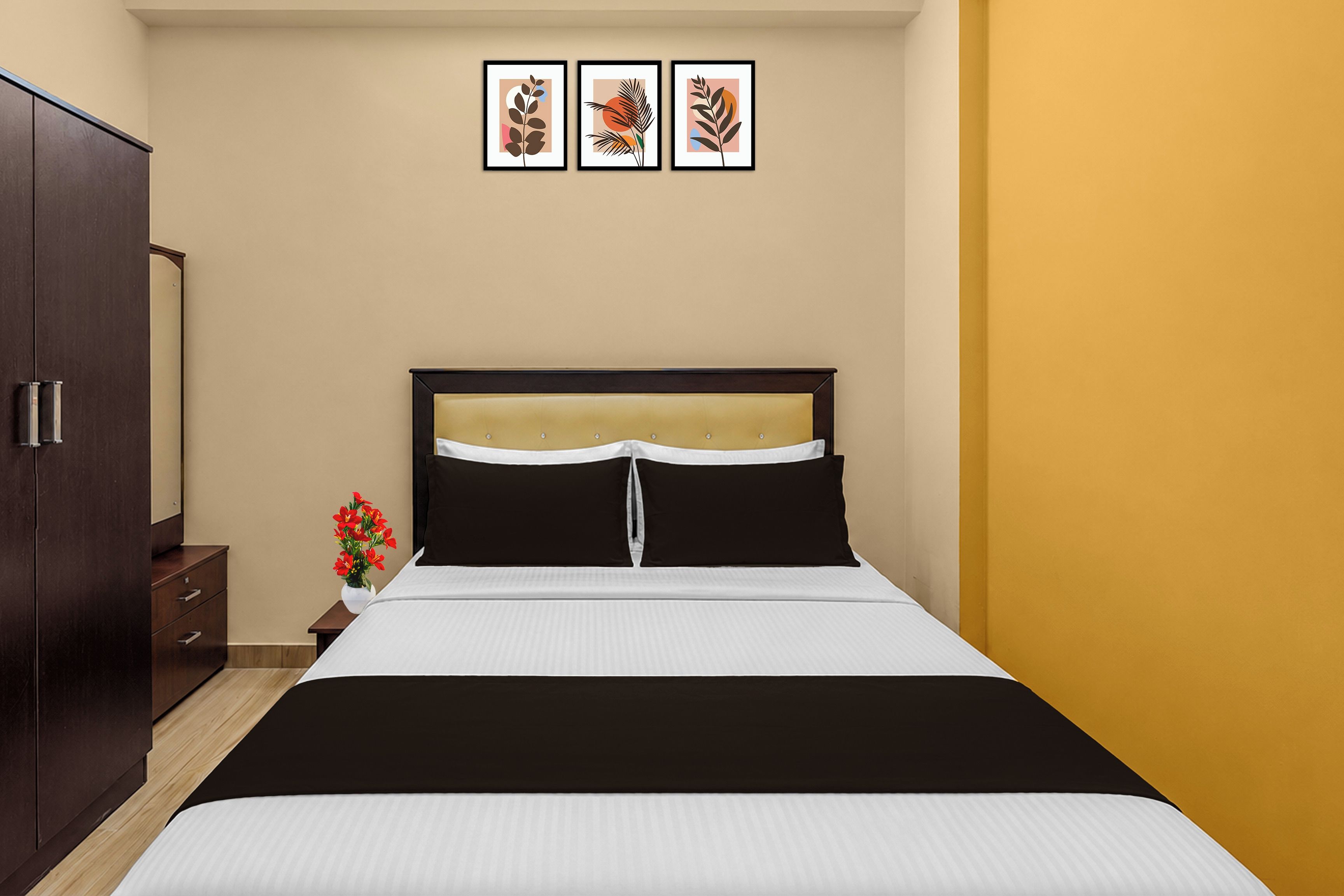 Un dormitorio con cama, armario, mesita de noche y tres cuadros en la pared.