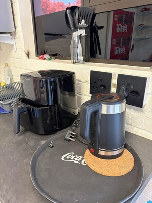 Eine Küchenarbeitsfläche mit Kaffeemaschine, Toaster und Wasserkocher.
