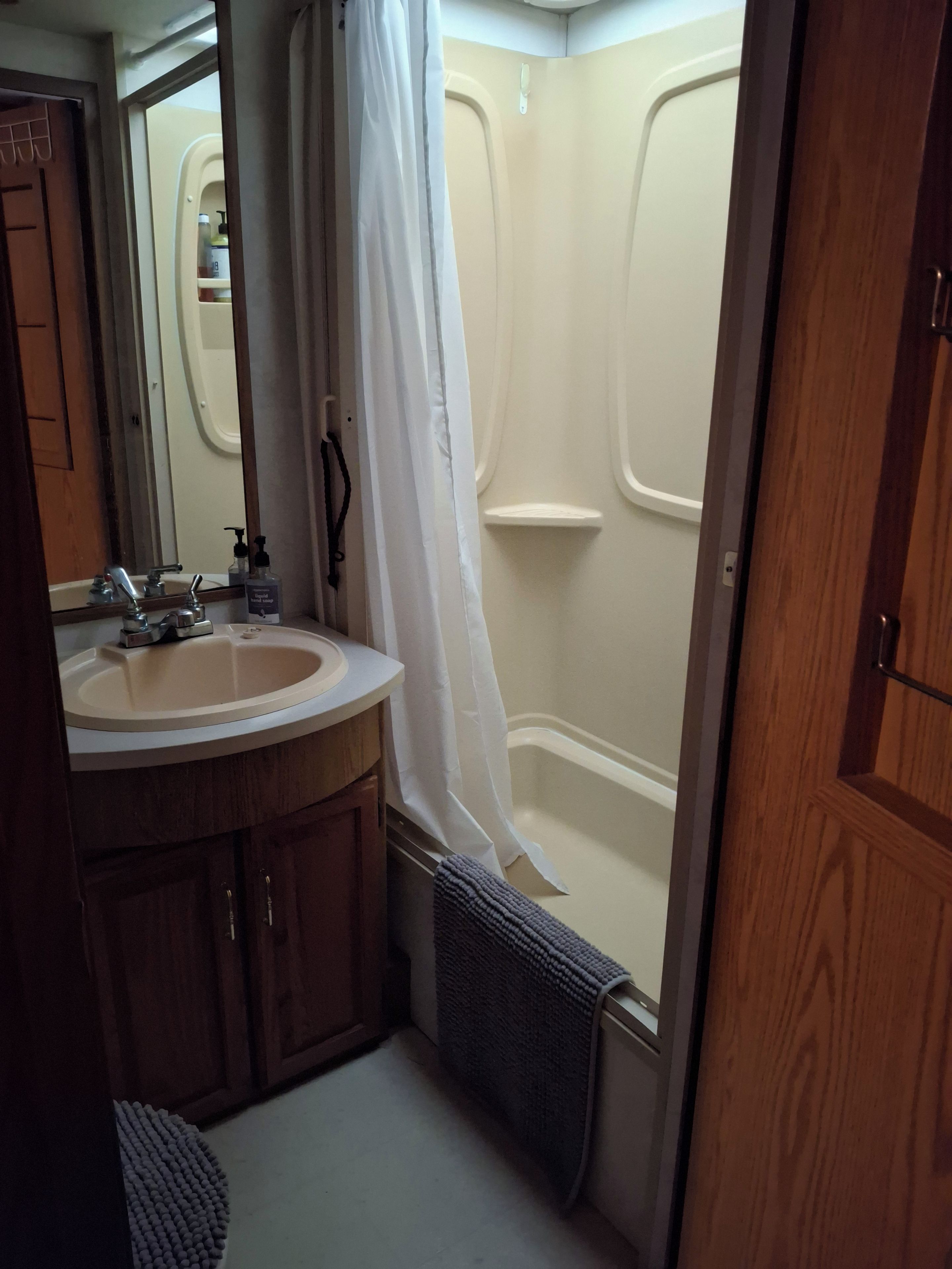 Un baño con lavabo, espejo y ducha.