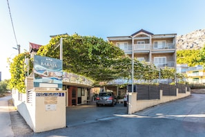 A multi-story building with a covered entrance and a sign for 'Villa Babadja.' - A6 - Spacious apartment with pool, 5 balconies and the sea view, near beach (Omiš)