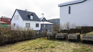 A residential area with houses, a no parking sign, and wooden pallets.