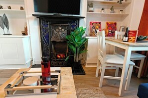 Ein Wohnzimmer mit Kamin, Esstisch, Stühlen und Couchtisch.