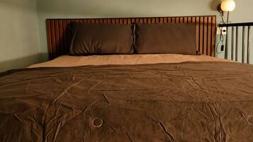 Un dormitorio con una cama grande, cabecero de madera y estante empotrado sobre la cama.