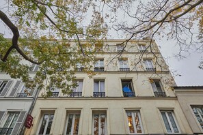 A multi-story building with balconies, windows, and a tree in the foreground. - Comfortable Air-conditioned Apartment - East Paris (Paris)
