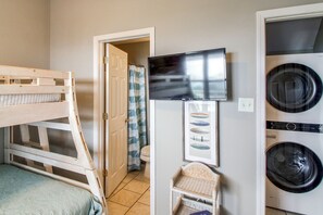 A laundry room with a washing machine, a dryer, a television, and a wooden bunk bed. - Unwind Poolside, Walk to Beach! Pensacola Getaway (Pensacola Beach)