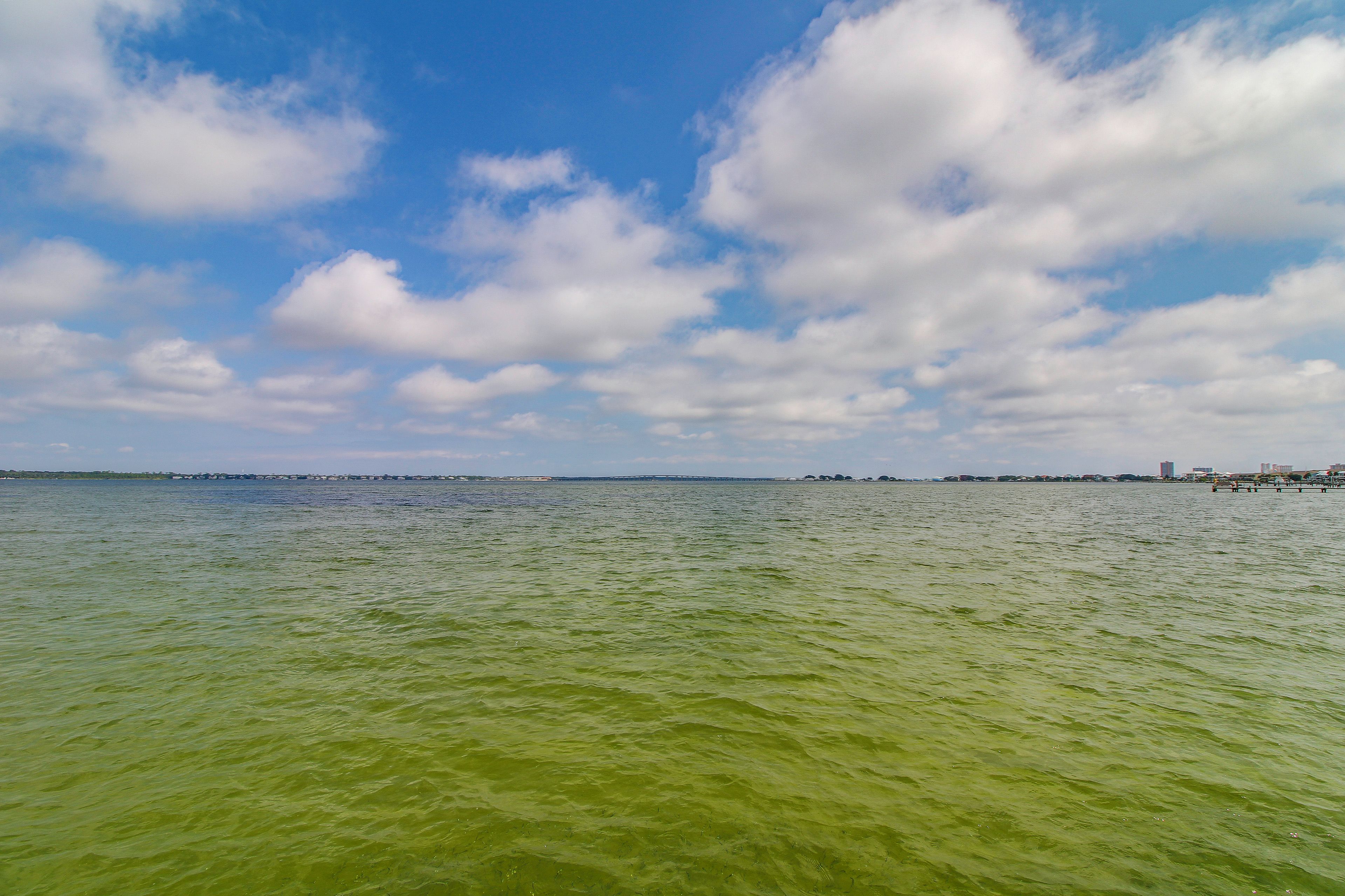 A body of water with a distant shoreline and a clear sky.