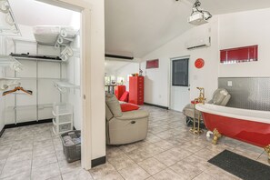 A room with a red bathtub, a beige sofa, and a red cabinet. - 6 Mi to Spanish Springs! Private Unit w/ Projector (Lady Lake)