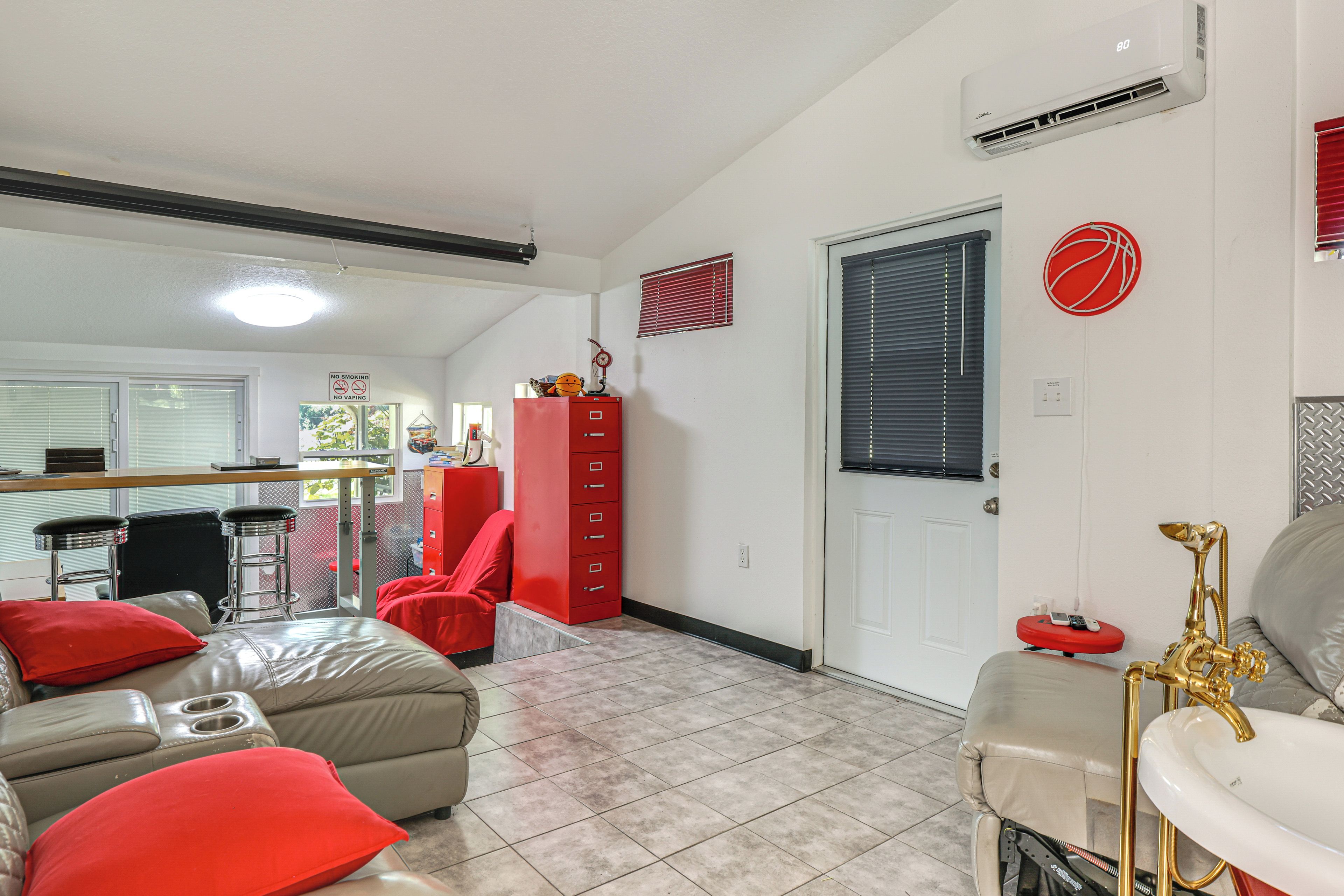 A living room with a sofa, a red cabinet, and a door with a window.
