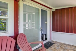 A covered porch with two red chairs, a door with a glass panel, and a metal trash can. - 6 Mi to Spanish Springs! Private Unit w/ Projector (Lady Lake)