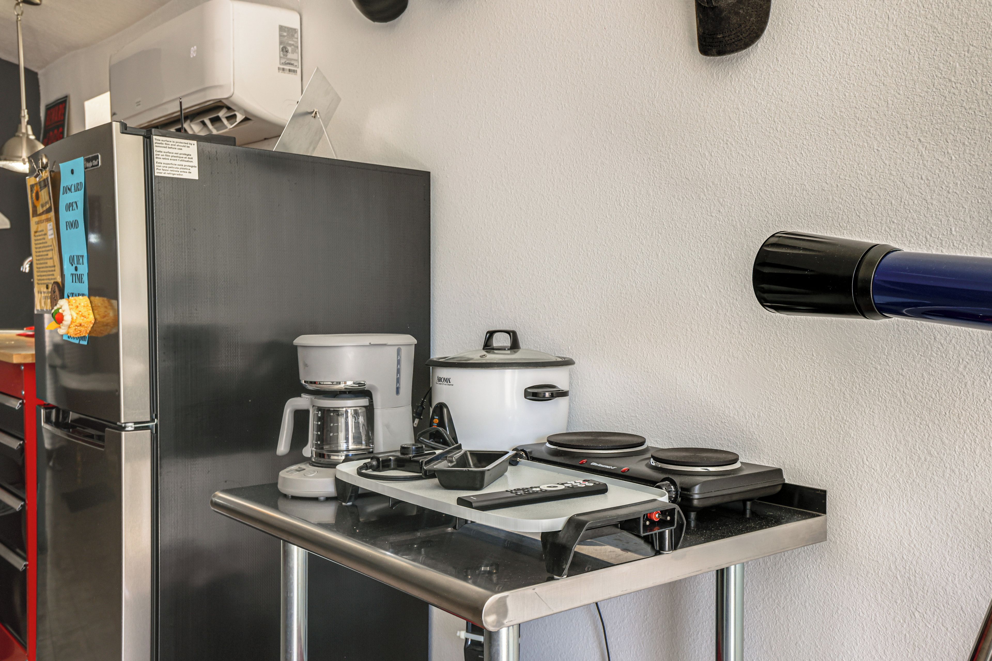 A kitchen with a refrigerator, coffee maker, and a microwave on the counter.