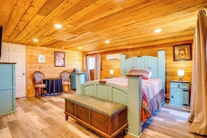A wooden-paneled room with a bed, a bench, a table, and a chair. - 6-acre Barndominium Escape, 6 Mi to Lake Cleburne! (Cleburne)