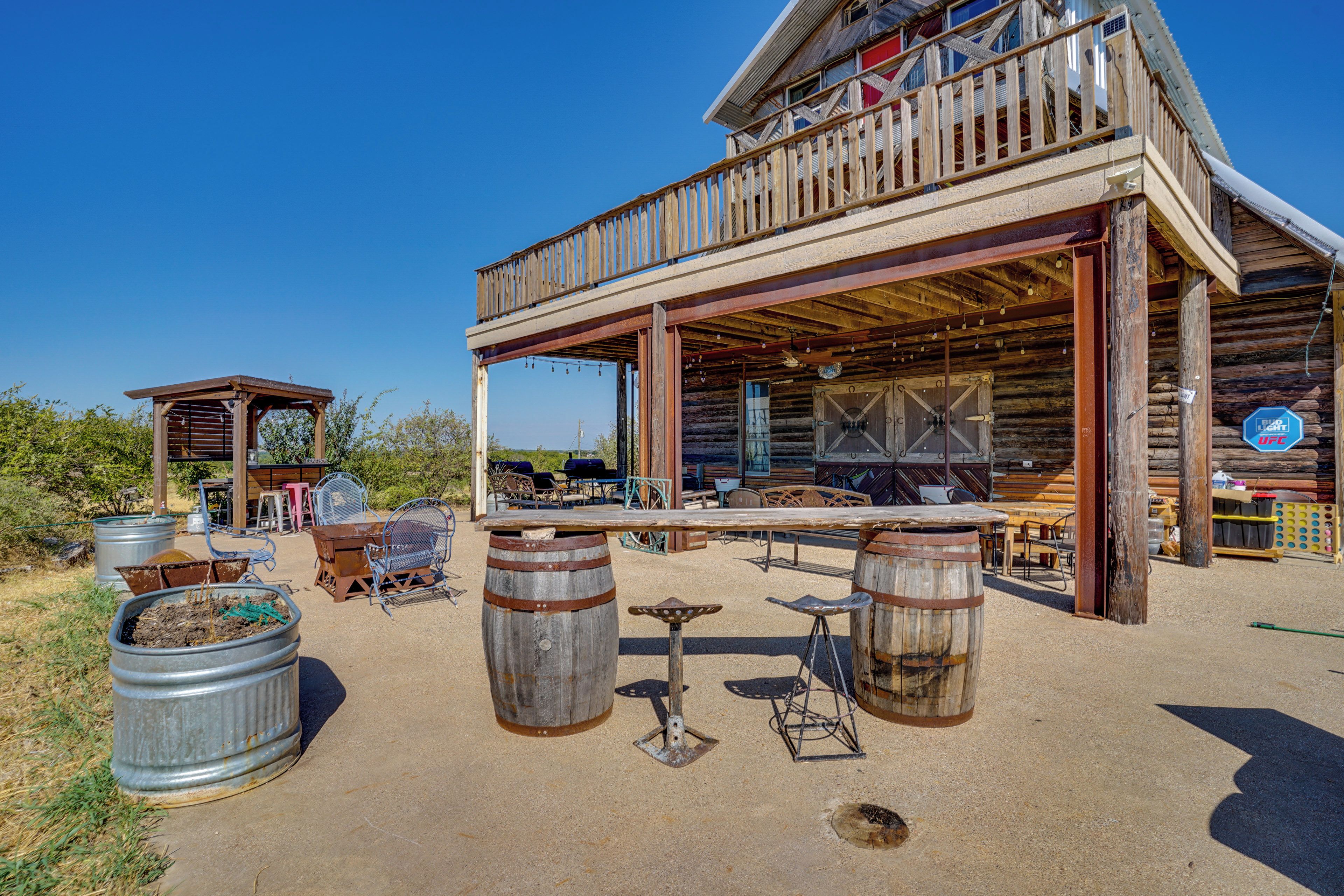 A rustic wooden building with a balcony, outdoor seating area, and a bar.