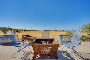 A metal chair and a rusty metal container with 'Hilltop Bar' written on it, set against a clear blue sky. - 6-acre Barndominium Escape, 6 Mi to Lake Cleburne! (Cleburne)