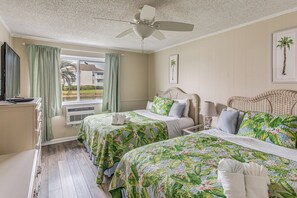 A hotel room with two beds, a ceiling fan, a window with curtains, and a view of the outside. - Walk to Ocean & Eats! Lake-view Myrtle Beach Haven (North Myrtle Beach)