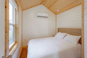 A bedroom with a bed, white bedding, a wooden ceiling, and an air conditioning unit. - Steinhatchee Escape! Perfect For Anglers + Hunters (Steinhatchee)
