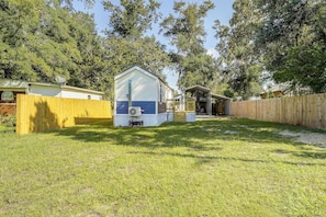 A small, single-story house with a fenced yard, a covered porch, and a satellite dish. - Steinhatchee Escape! Perfect For Anglers + Hunters (Steinhatchee)