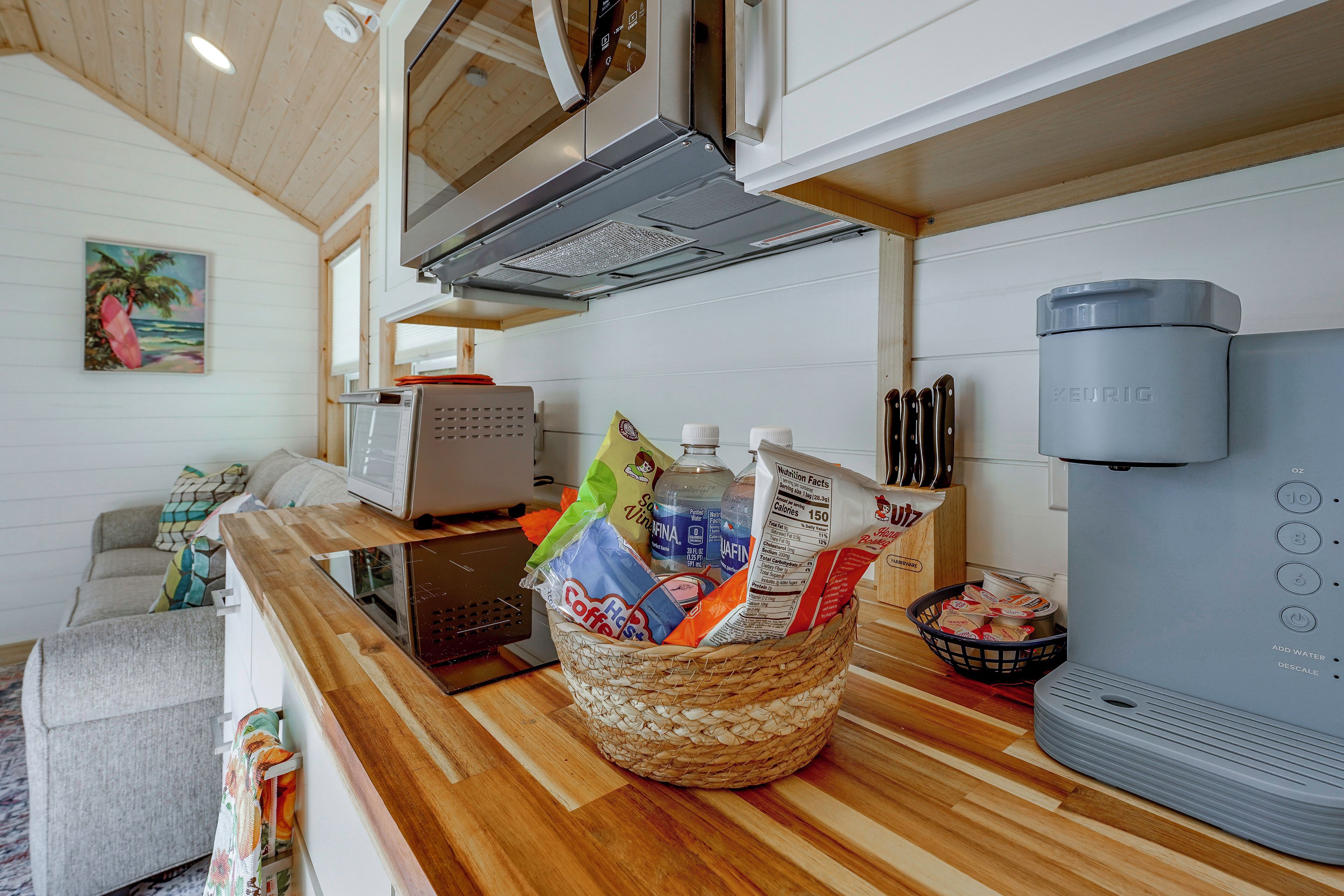 A kitchen with a coffee maker, a basket of coffee bags, and a water dispenser.