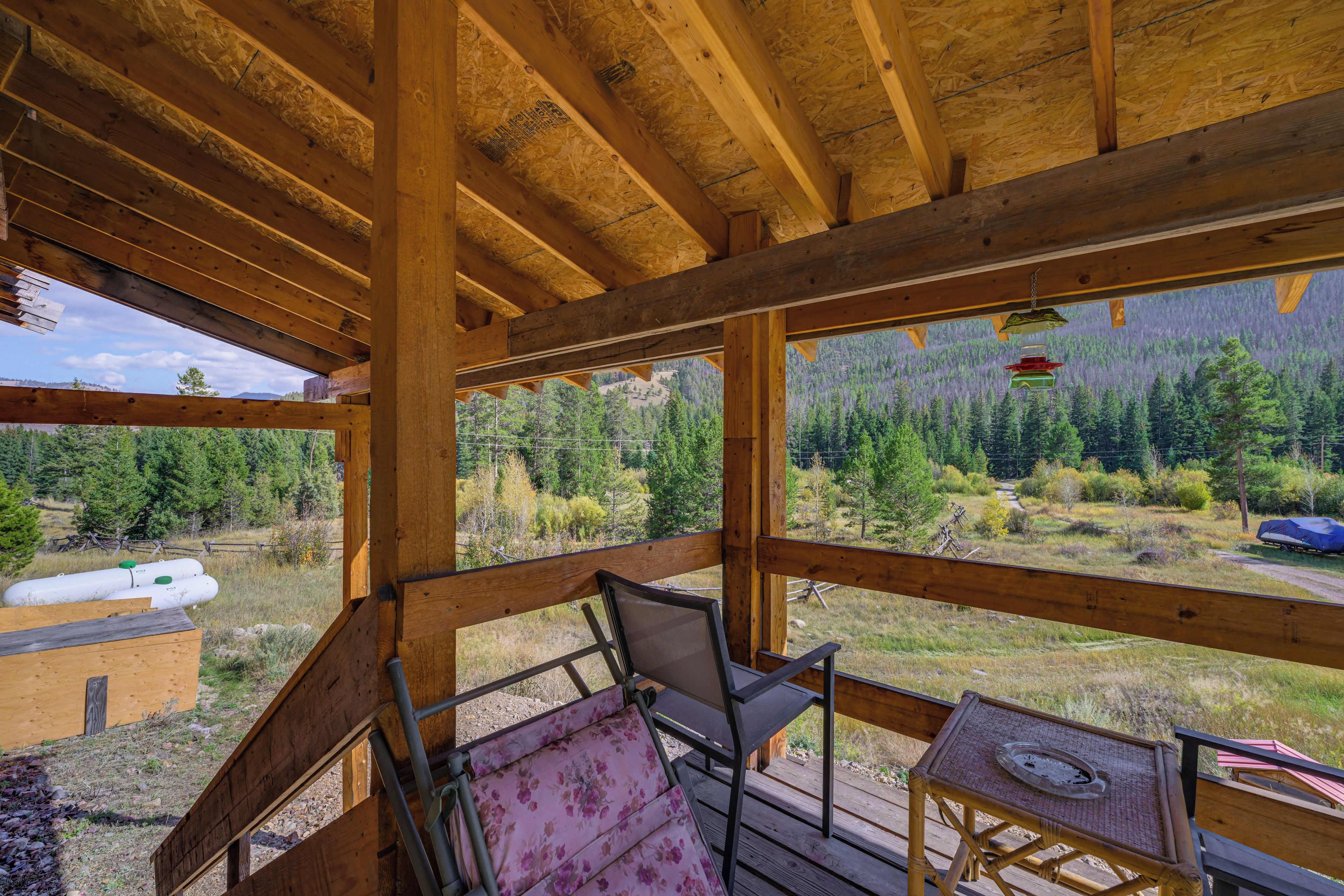 A wooden deck with a view of a forested mountain range.