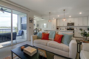 En moderne stue med sofa, sofabord og udsigt til terrassen.
