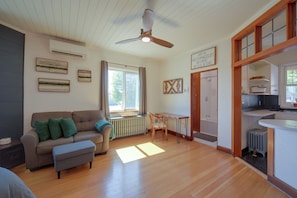 A living room with a sofa, a table, and a ceiling fan. - Charming Couple's Gem in Duluth w/ Enclosed Porch (Duluth)