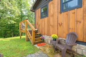 A wooden house with a stone foundation, a wooden staircase, and a chair outside. - Deer Lodge Cabin by the French Broad River (Brevard)