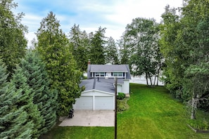 A residential property with a two-story house, a garage, and a well-maintained lawn.