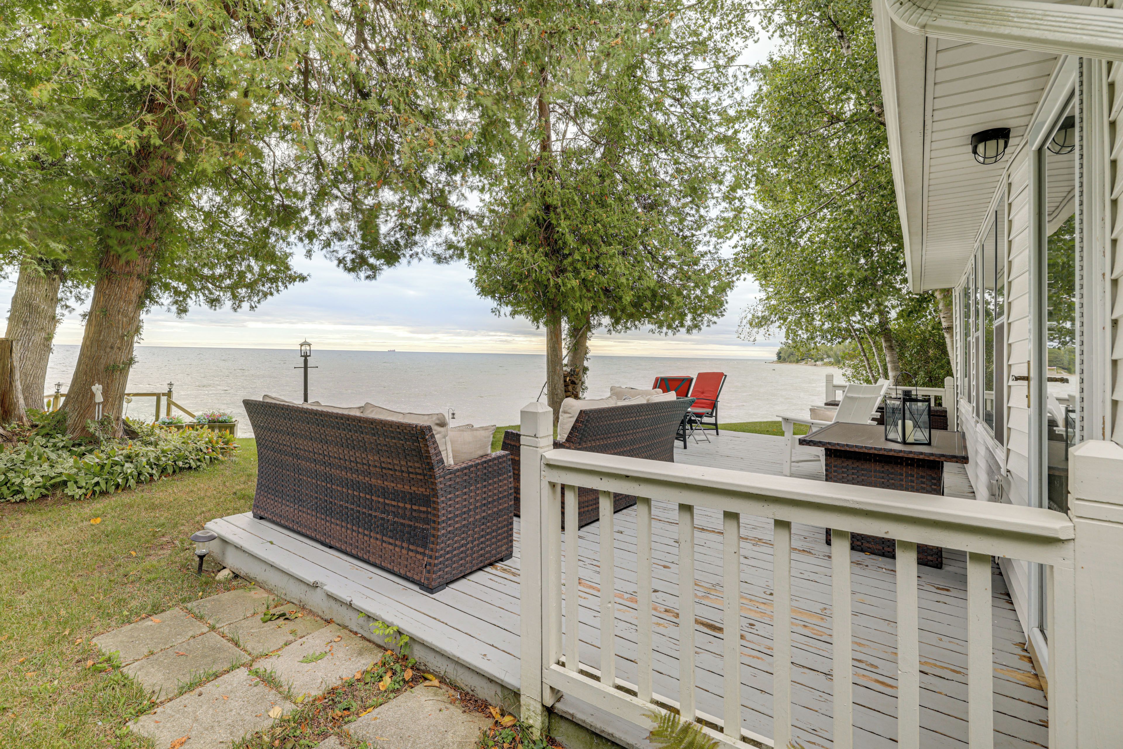 A deck with outdoor furniture overlooking a body of water.