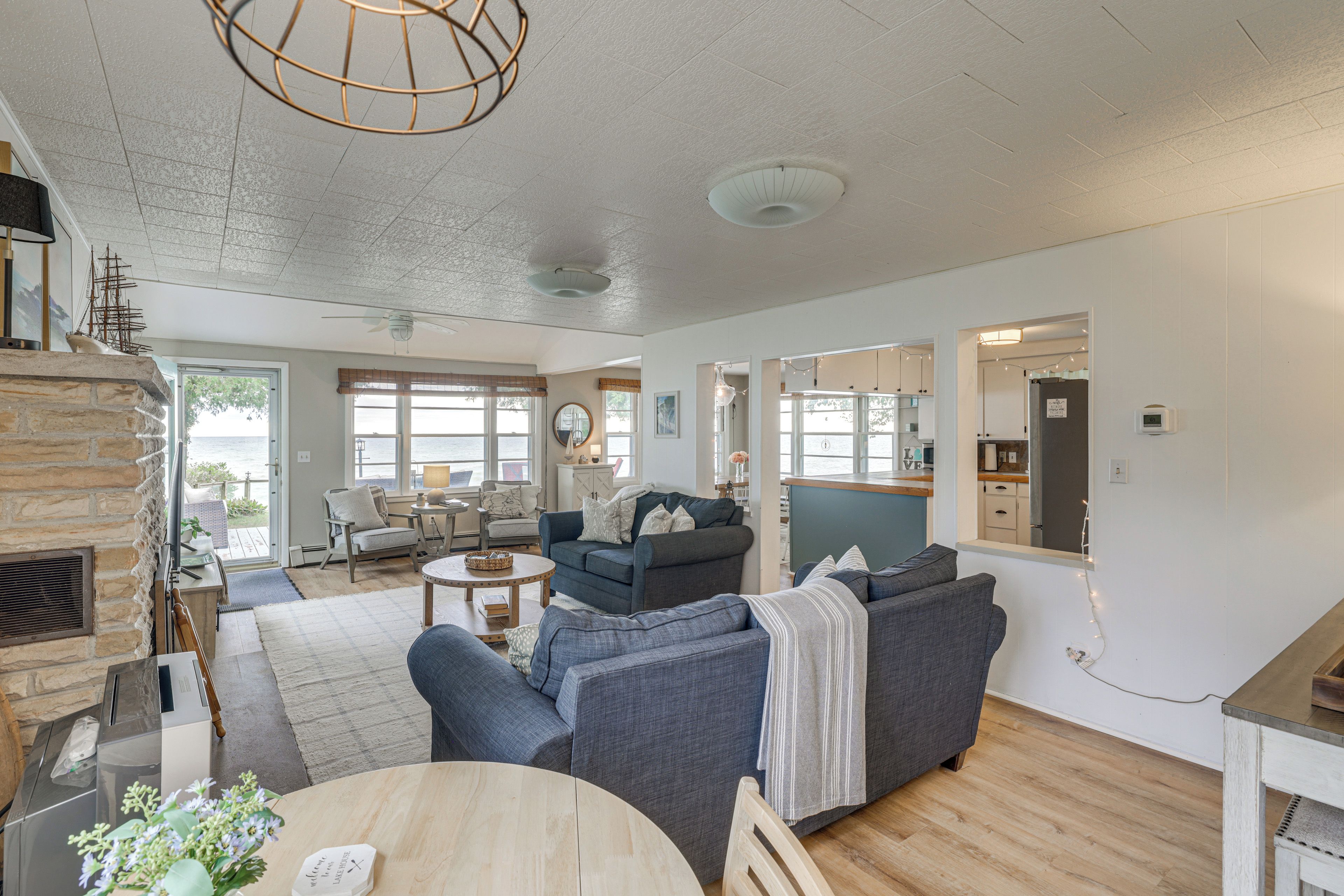 A spacious living room with a fireplace, seating area, and large windows offering a view.