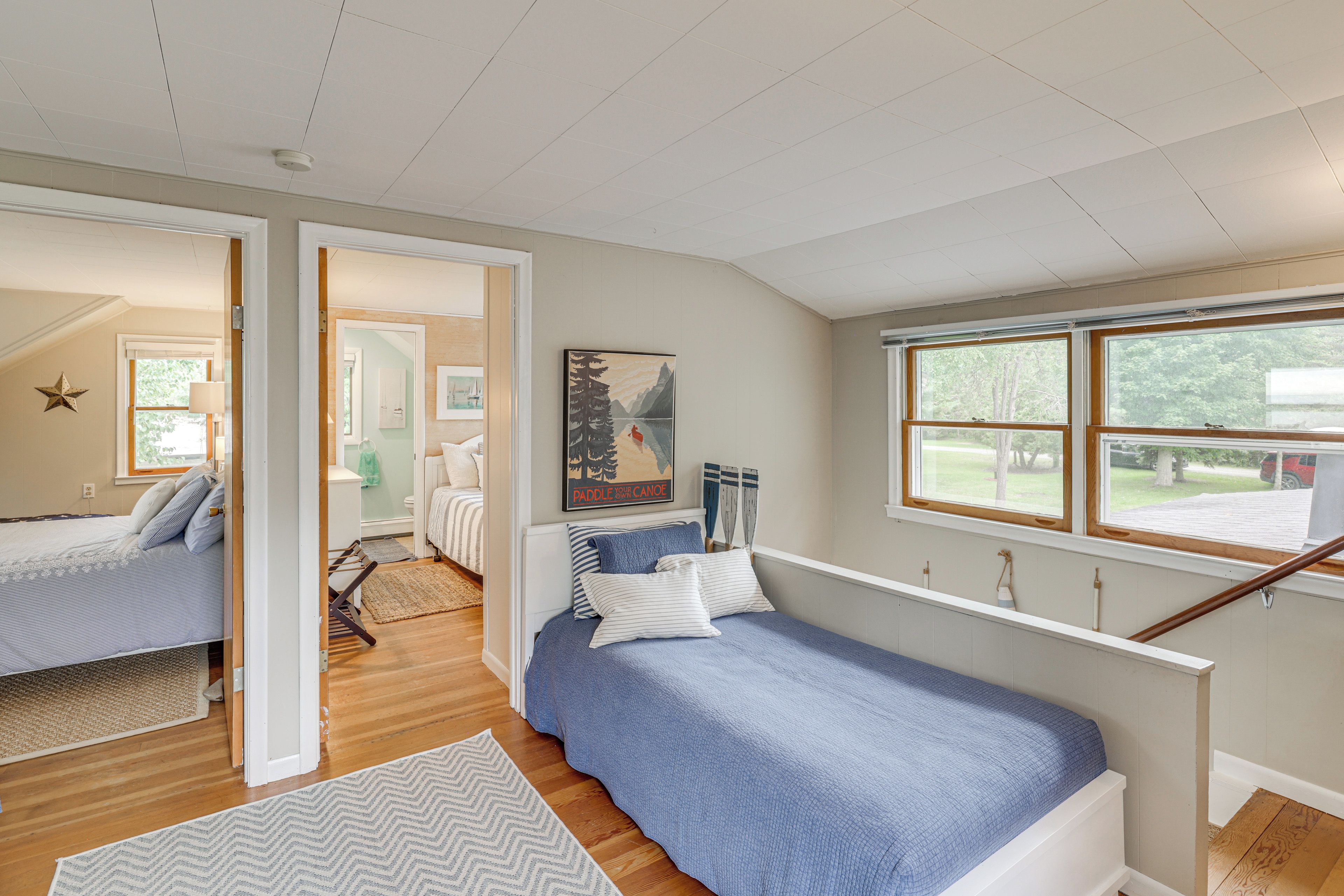A bedroom with a bed, a window, and a view of the outdoors.