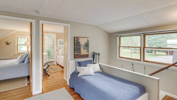 A bedroom with a bed, a window, and a view of the outdoors.
