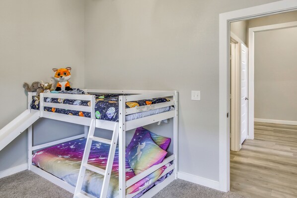 A bunk bed with a galaxy-themed mattress cover and a small toy fox on the top bunk. - Play & Unwind! Home w/ Fenced Yard in Amarillo (Amarillo)