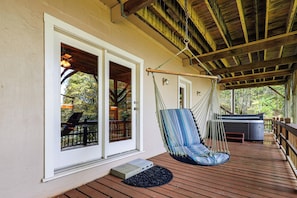A wooden deck with a hammock, a hot tub, and a door leading to a covered area. - Hot Tub & Mtn Views: Wolf Laurel Home (Mars Hill)