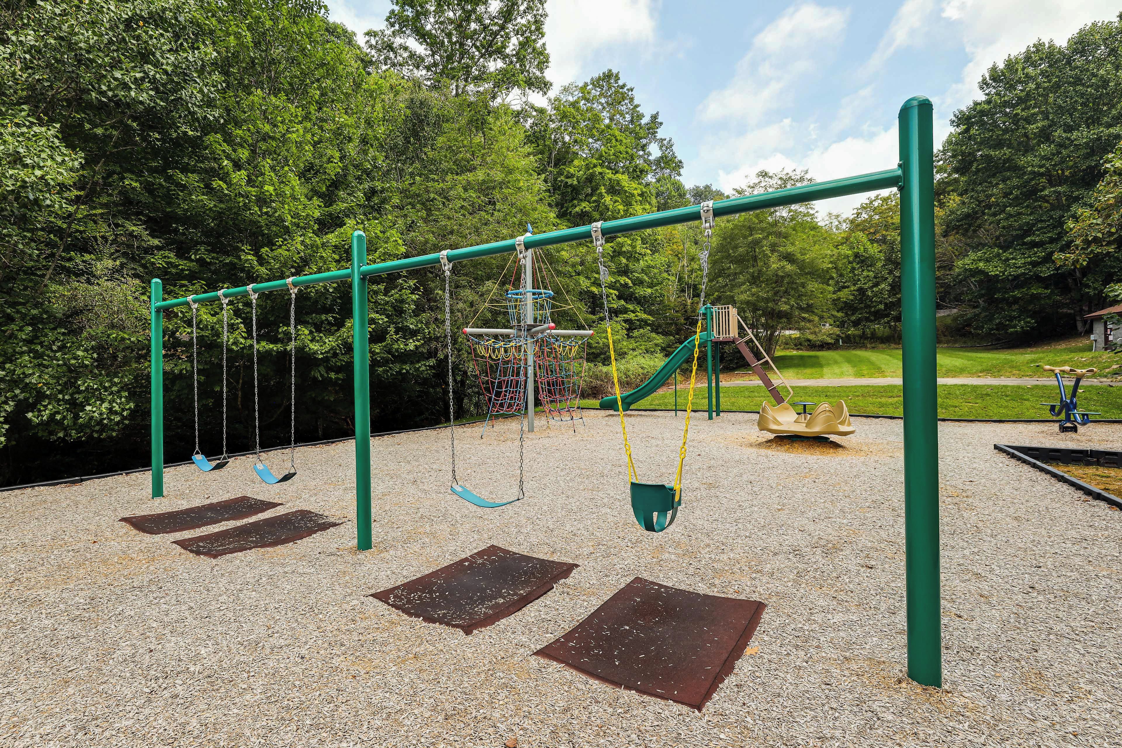 A playground with swings, a slide, and a climbing structure.